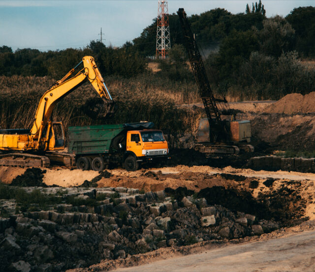 Closeup shot of an ongoing construction  with tracks and a bulldozer on an  abandoned land